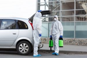 Man in hazmat suits buying disinfection spray for home cleaning